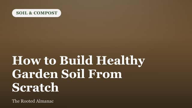 Layers of dark compost and topsoil being added to a freshly built garden bed